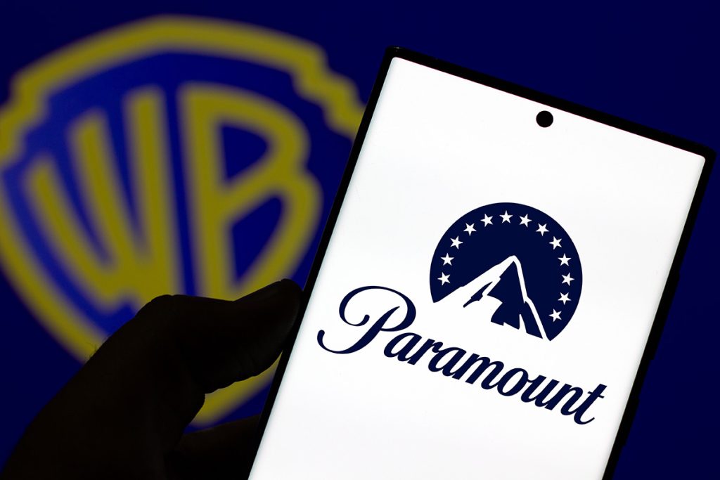 Paramount logo on Smartphone with Warner Bros logo behind